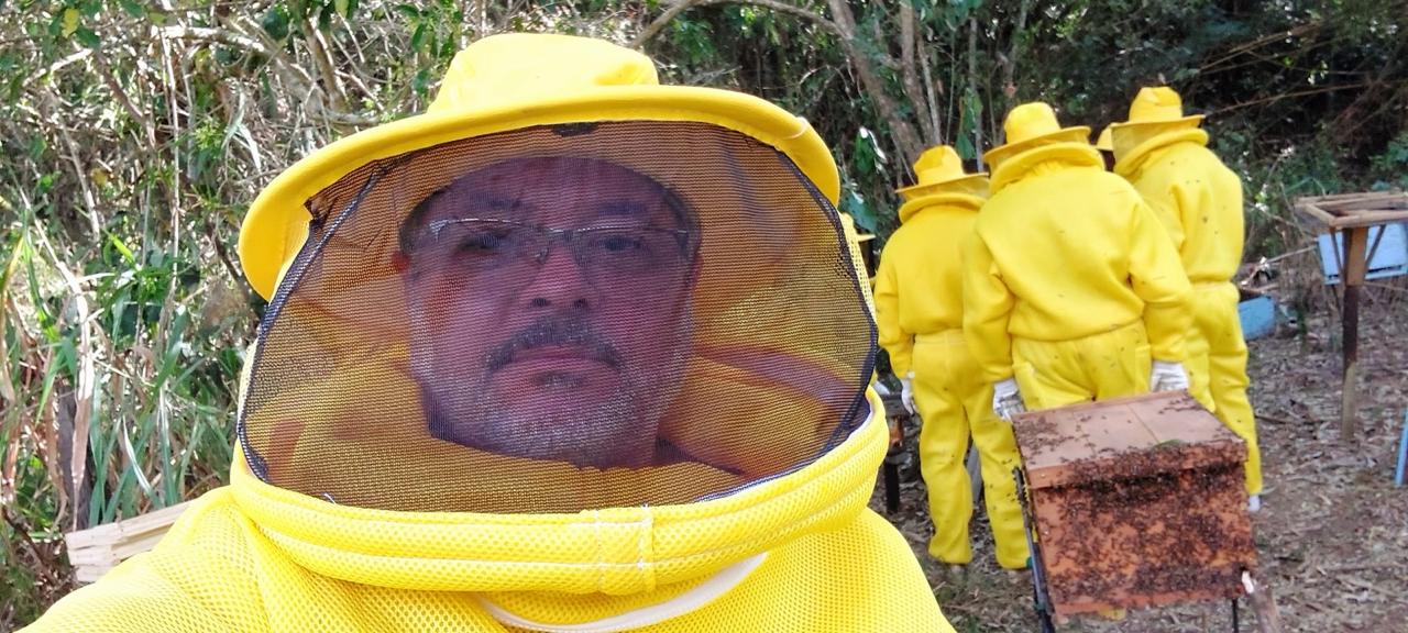 Apicultor com máscara de proteção durante o manejo das colmeias